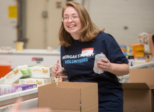 smiling woman holding a can in front of a box