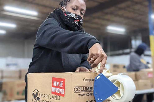 masked woman putting packing tape on BUBs