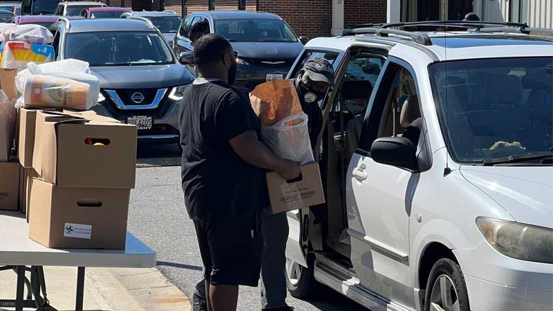 black man loading food boxes in van