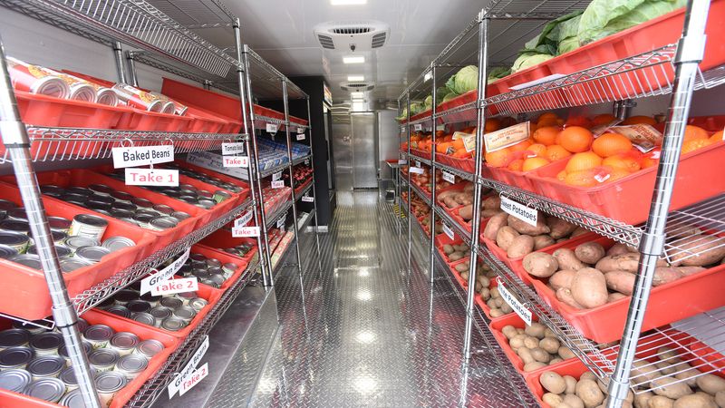 aisle inside the Mobile Market with fresh produce on shelves on right canned good on shelves on left