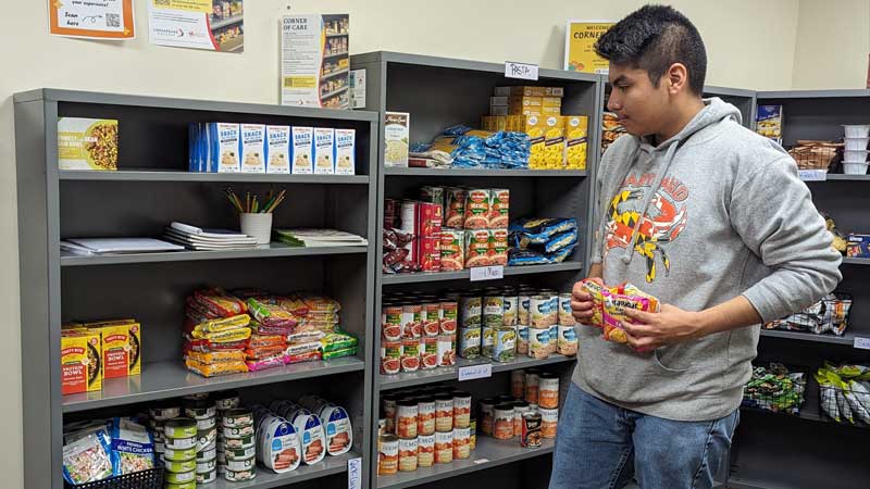 Latino college student getting food in school pantry