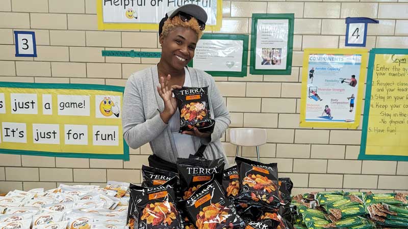 young black woman holding food bags in elementary school
