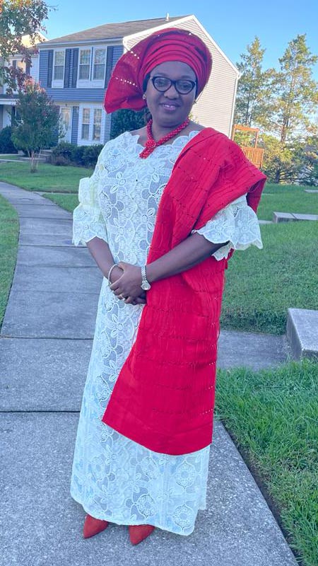 Bukola Daramola standing outside in red and white dress