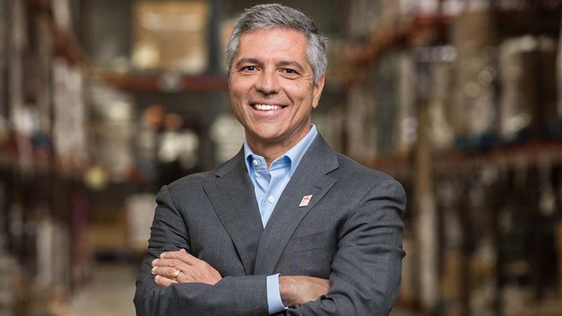 Carmen Del Guercio in suit standing with arms crossed in warehouse