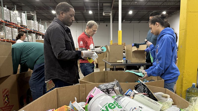 various volunteers sorting food in the Maryland Food Bank warehouse