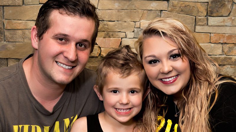 caucasian father, son, & mother smiling for the camera