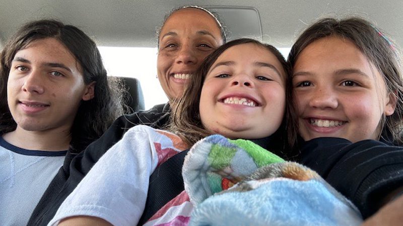 Dyani Hanrahan with her kids in the back seat of a car