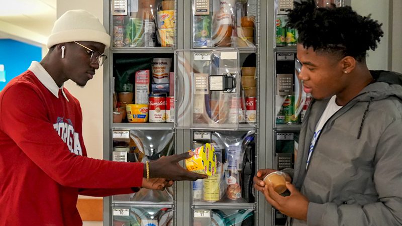two black college students looking at groceries in school pantry