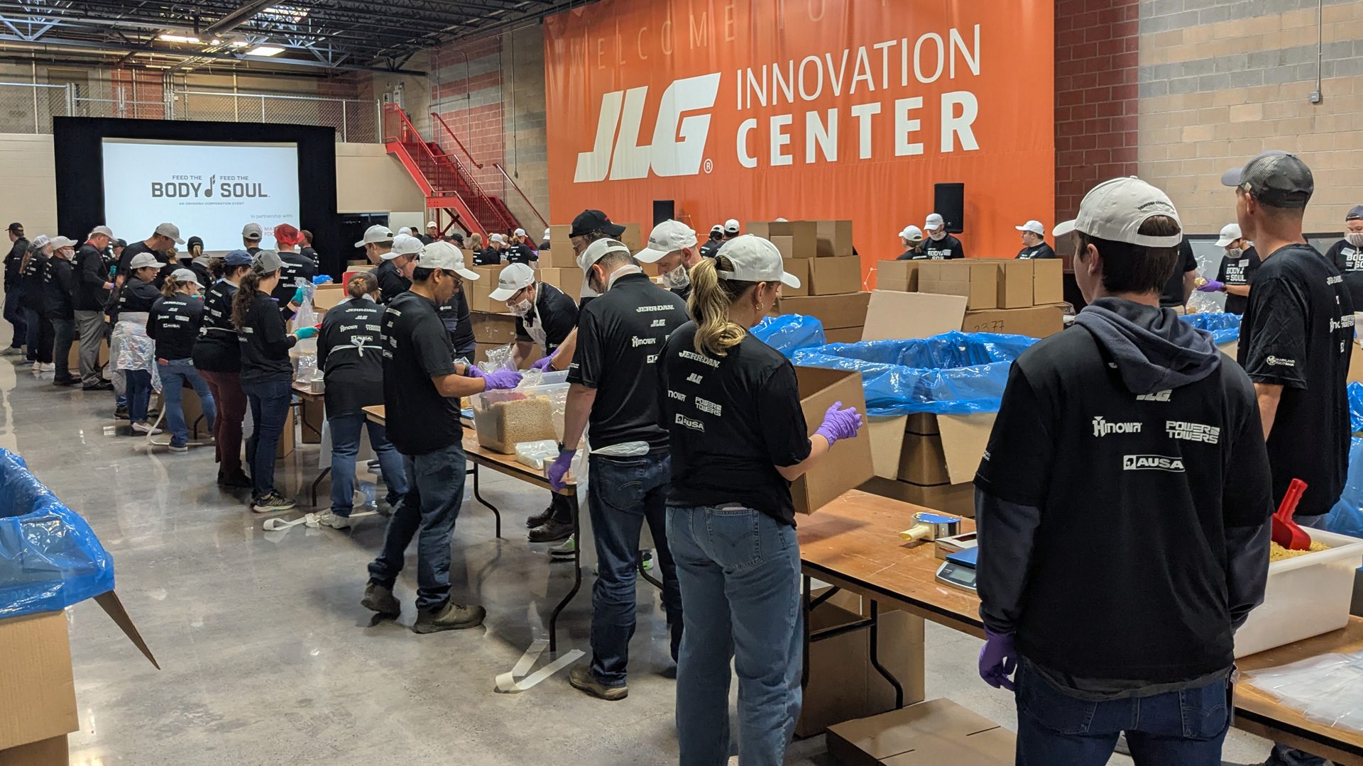 OshKosh team packing 30,000 pounds of pasta in boxes in the JLG Innovation Center