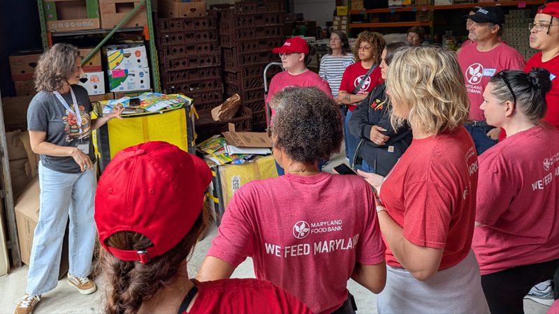 Maryland Food Bank staff members listening to coordinator in warehouse