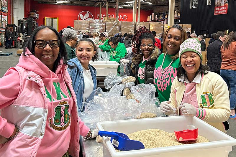 AKA volunteers smile around a table at Maryland Food Bank for Martin Luther King, Jr. Day of Service