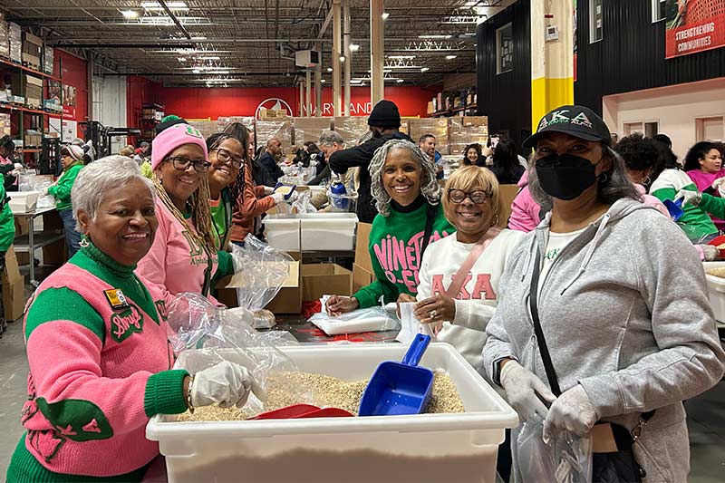 AKA volunteers smile around a table at Maryland Food Bank for Martin Luther King, Jr. Day of Service