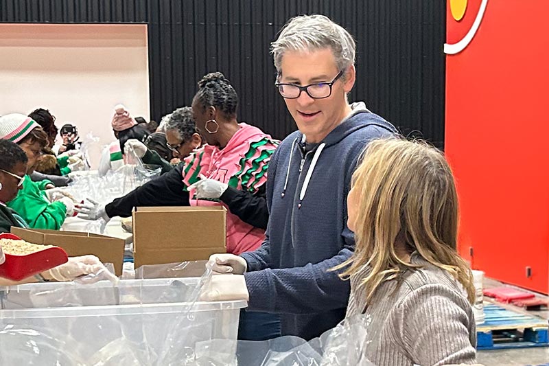 adult man and female child talking to each other while repackaging bulk rice at Martin Luther King, Jr. Day of Service event