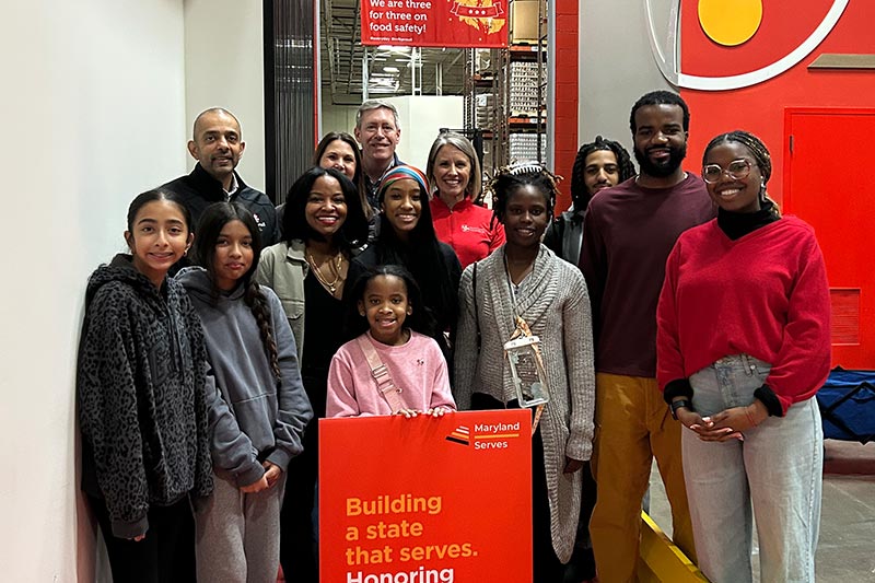 Maryland Food Bank volunteers representing Maryland government agencies pose in warehouse