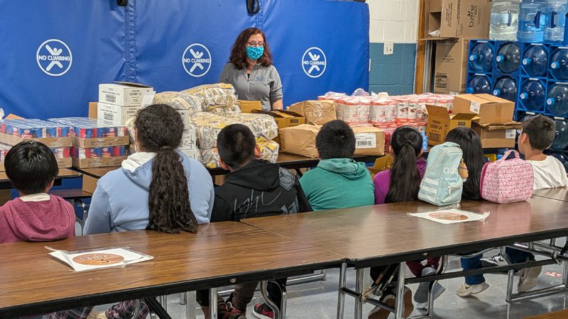 Wolfe Street Academy students learning how to pack various foods for neighbors to carry home