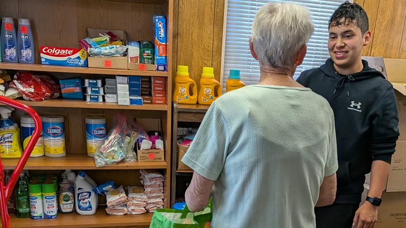 youth volunteer helps an elderly woman at Lansdowne High School's Viking food pantry
