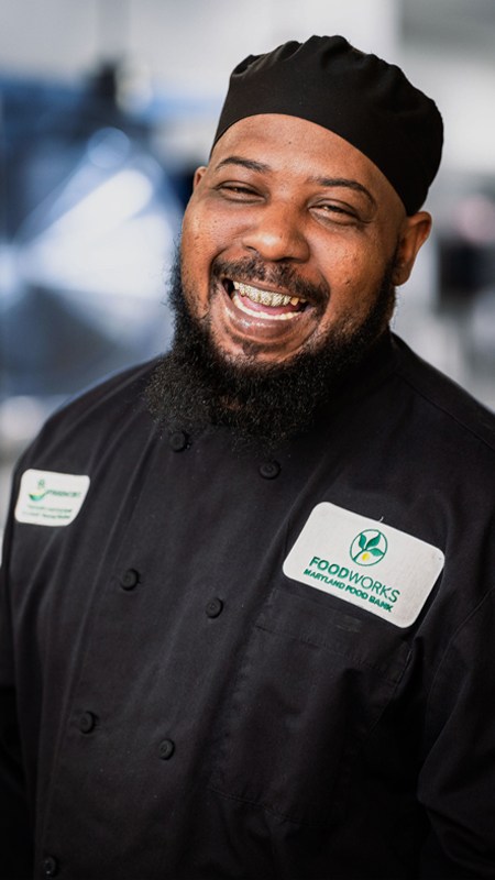 Eric Latta in his FoodWorks chef uniform laughs for the camera